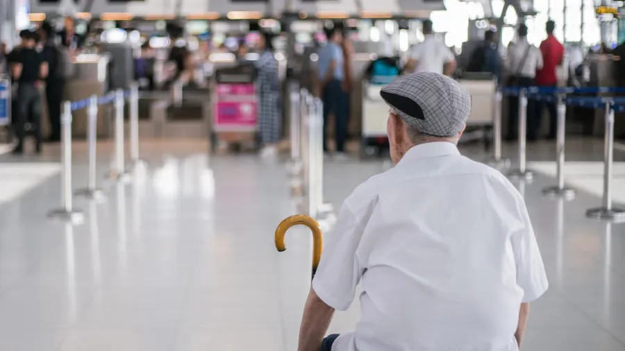 elder man sitting in front of the check in counter