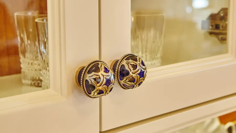elegant blue and gold cabinet knobs on cream cabinetry in