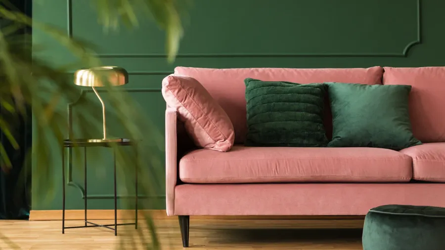 emerald green pillows on pastel pink couch in stylish living