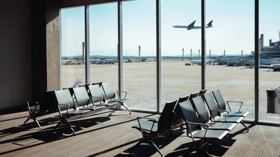 empty airport terminal seating area with a large window view