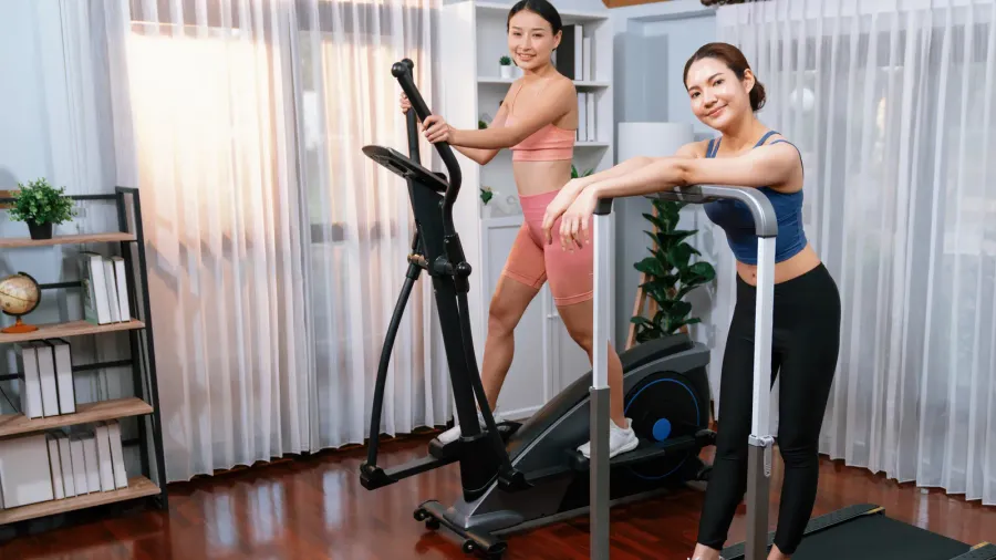 energetic and strong athletic asian woman running on elliptical running