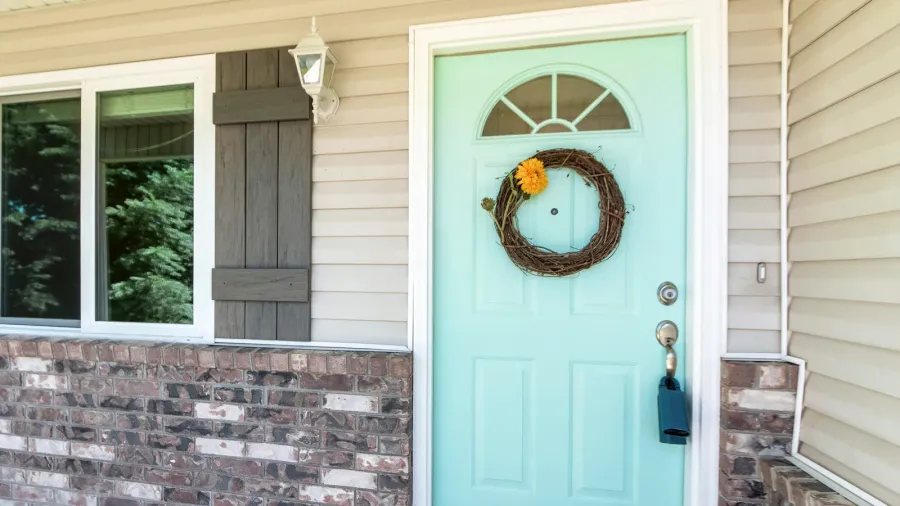 entrance of a house with brick walls and vinyl sidings