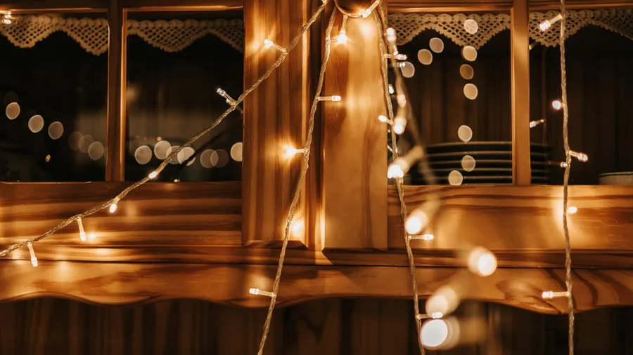 Illuminated string lights draped around a wooden window.