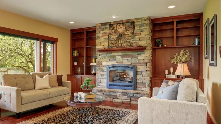Family room in antique style with natural stone design fireplace and built-ins.