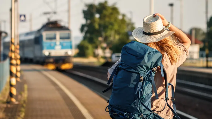 female backpacker traveling by train alone woman with backpack and