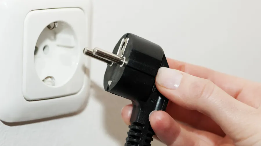 female hand unplugging a plug