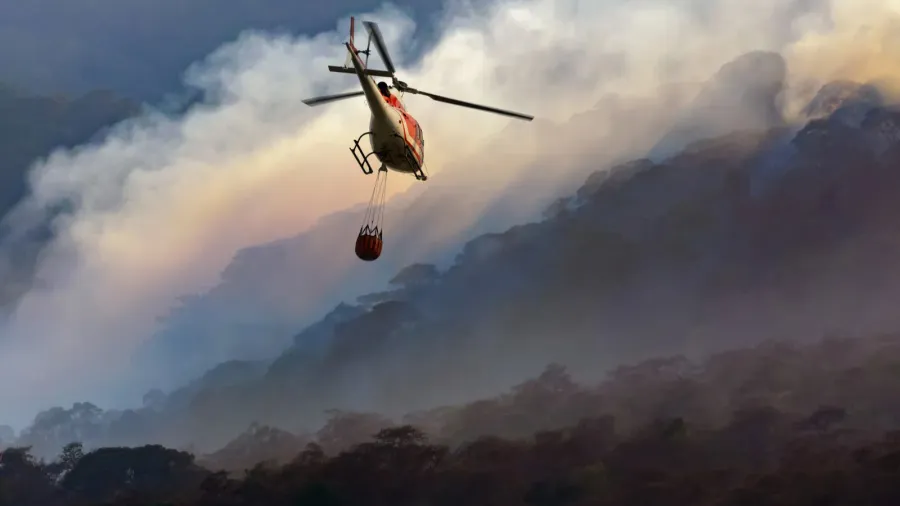 fire fighting helicopter carry water bucket to extinguish the forest
