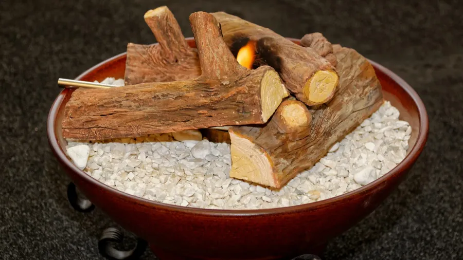 A portable firepit with firewood in it.