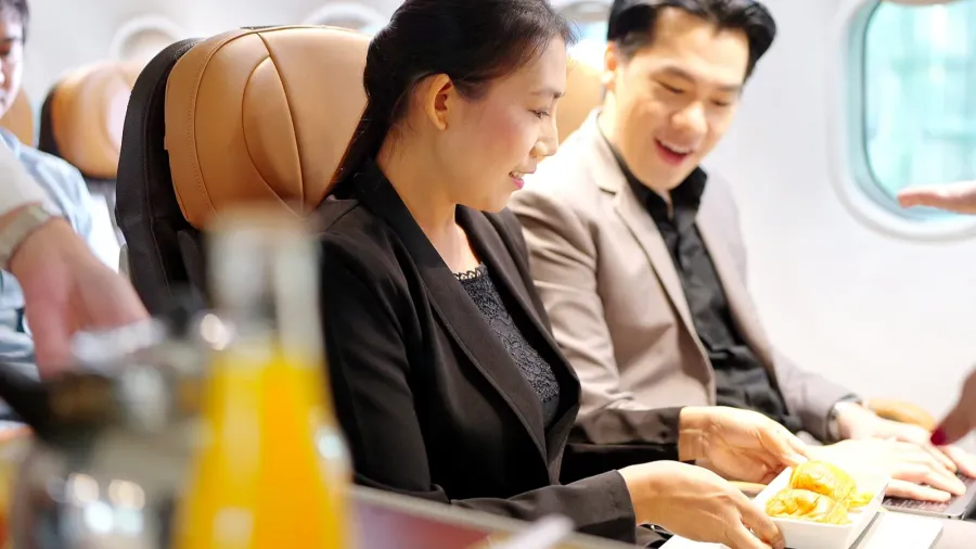 flight attendant serving food drink and talking to passengers on