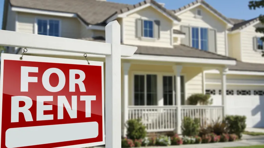 for rent real estate sign in front of house