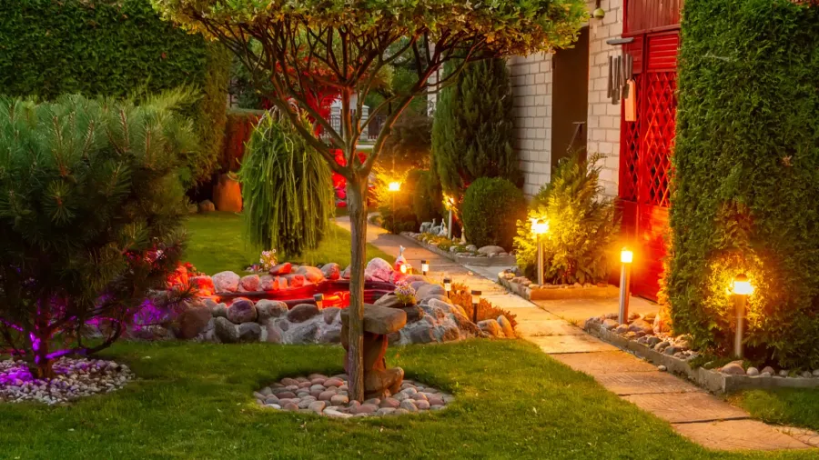 A garden with solar powered path lights along the walkway.