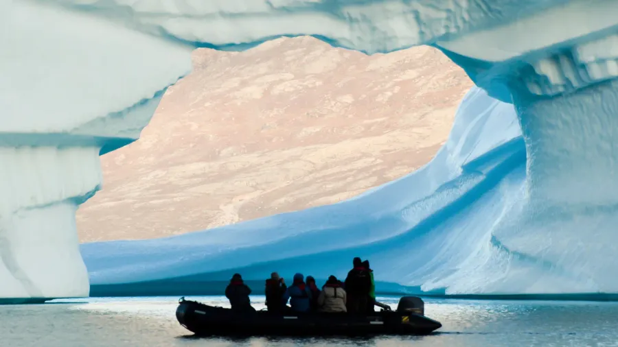 giant iceberg with inflatable zodiac boat  greenland