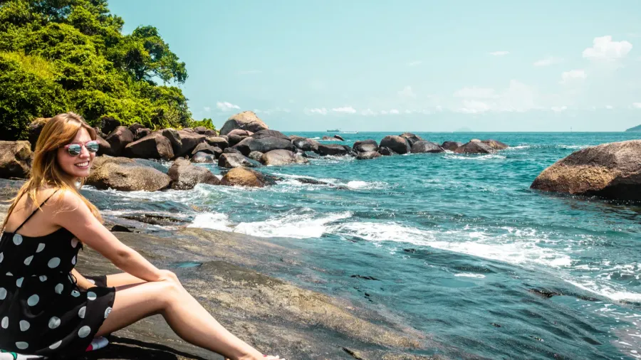 girl in a rock beach at beautiful island ilhabela brazil