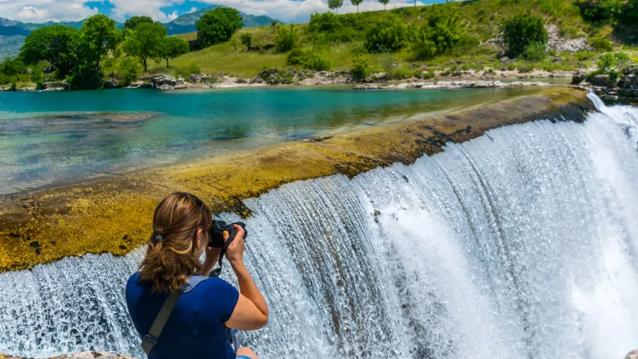 girl photographer takes pictures of niagara falls in montenegro