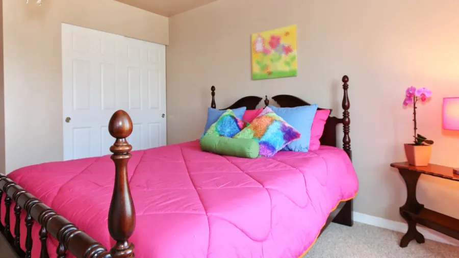 girls pink bed with colorful pillows