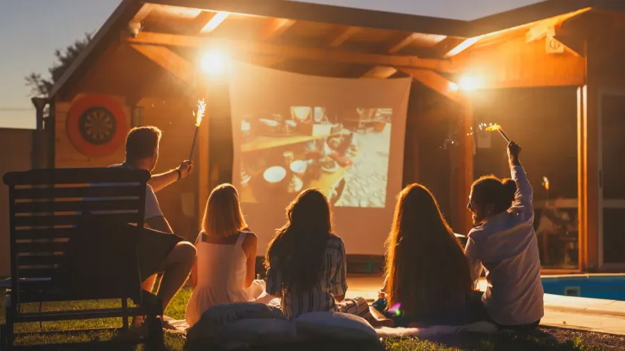 group of cheerful young friends watching a movie in an