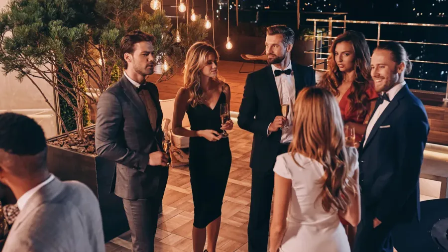 group of people in formalwear communicating and smiling while spending