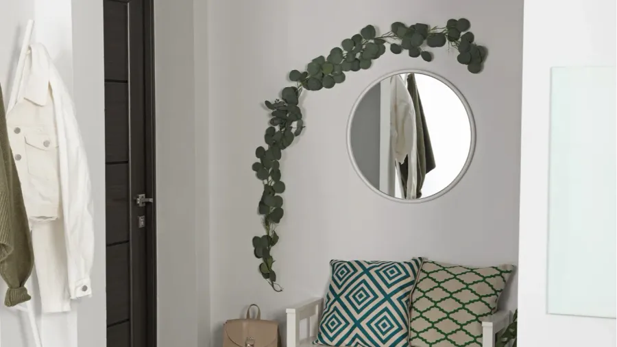 hallway interior with stylish furniture and round mirror on light