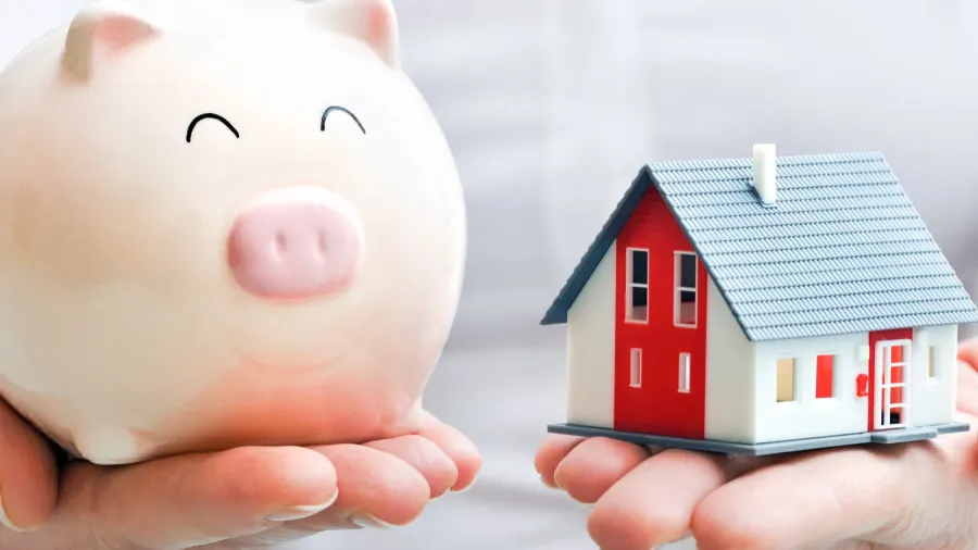 hands with piggy bank and house model
