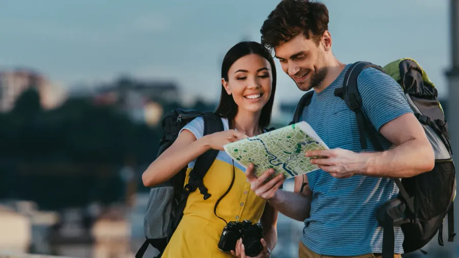 handsome man and asian woman smiling and looking at map