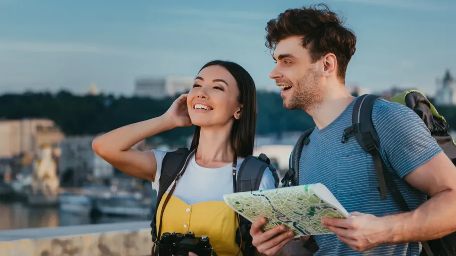 handsome man holding map and asian woman looking away