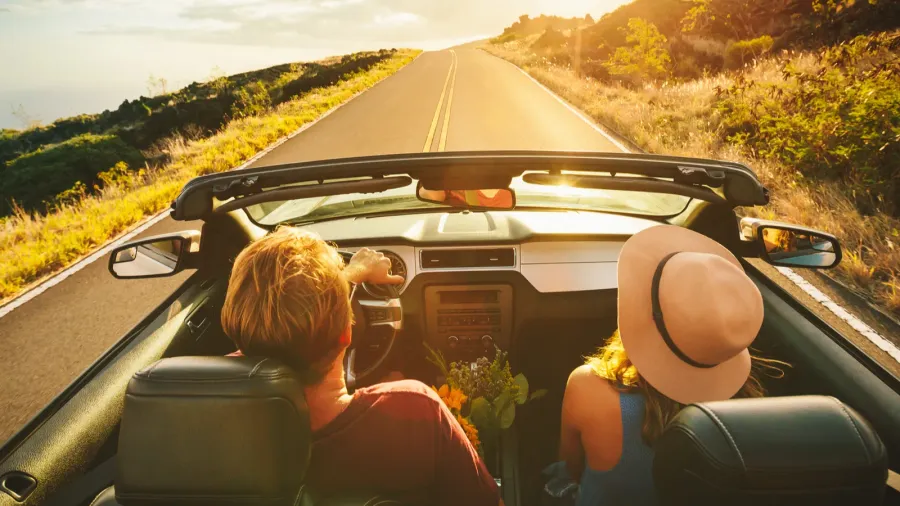 happy couple driving in convertible