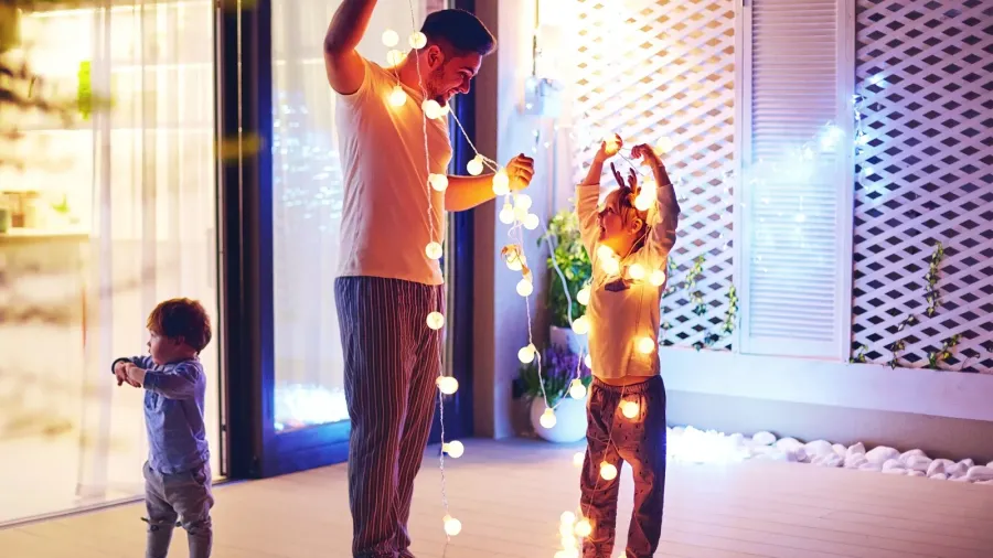 happy family, father with sons decorate open space patio area with christmas garlands
