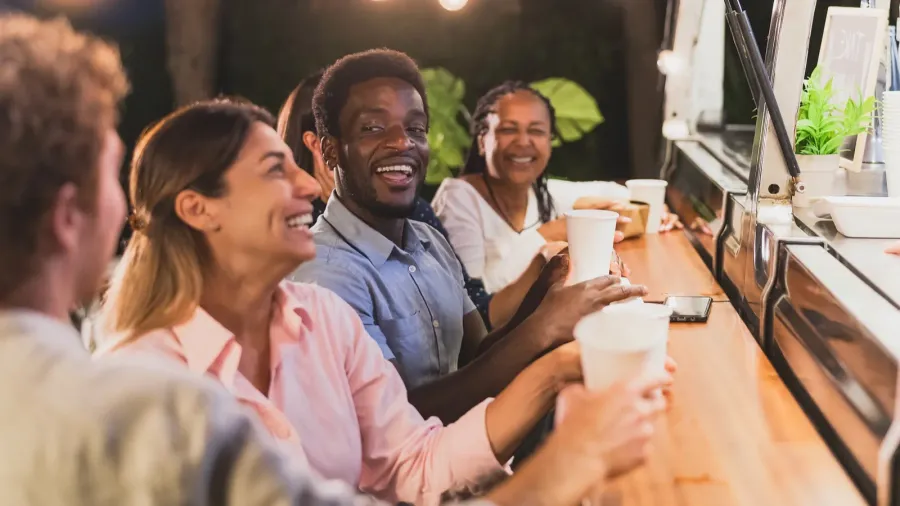 happy multiracial people buying meal from food truck kitchen