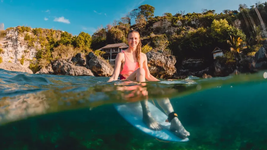 happy surfer girl with surfboard surfer sit at board in
