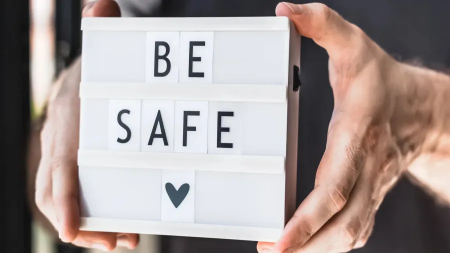 healthcare and safety concept unrecognised man holding lightbox with text