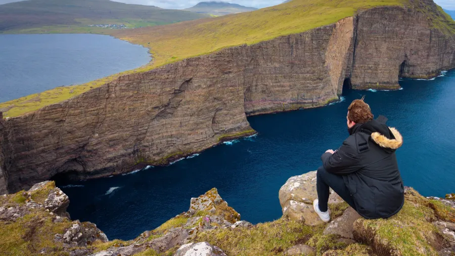 hiker looking at the lake sorvagsvatn on faroe islands