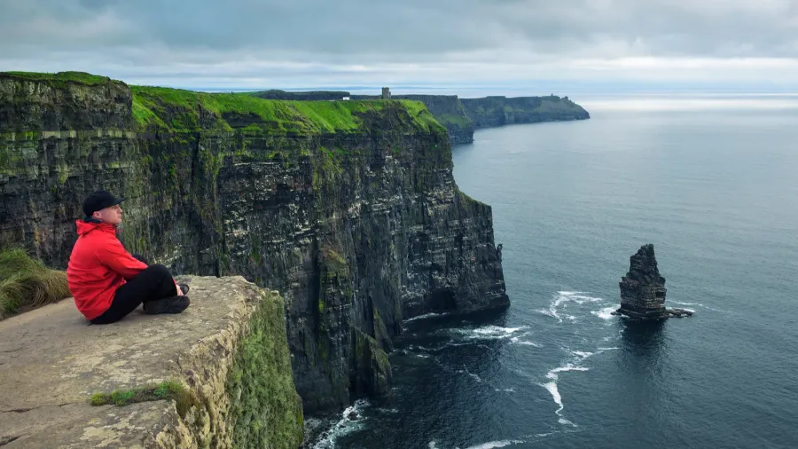 hiker sitting at the cliffs of moher