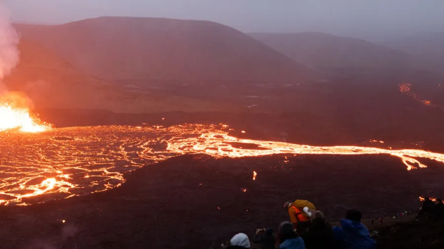 hikers watching the meradalir eruption of fagradalsfjall volcano in iceland
