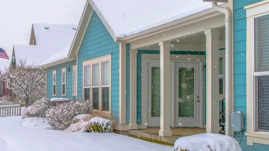 homes with snow covered roofs and yards in winter