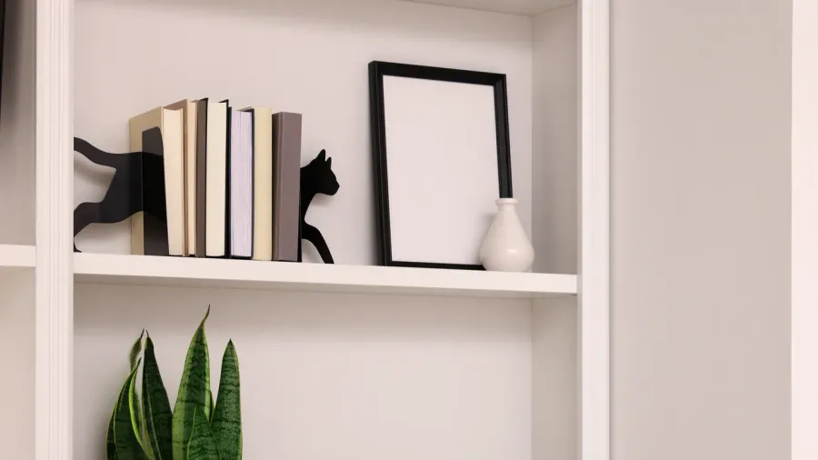 A shelf with stacked books, a blank photo frame, and a small plant, complemented by a decorative cat silhouette.