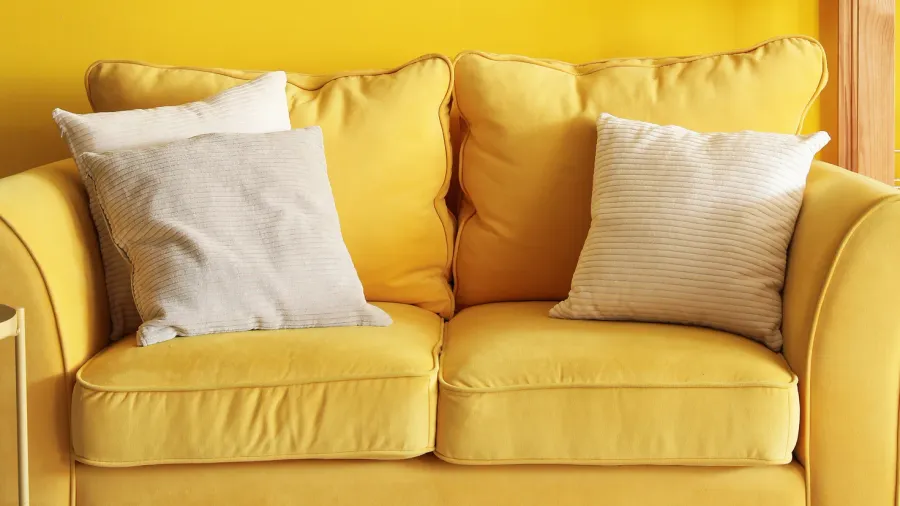 interior of living room with yellow sofa and frames