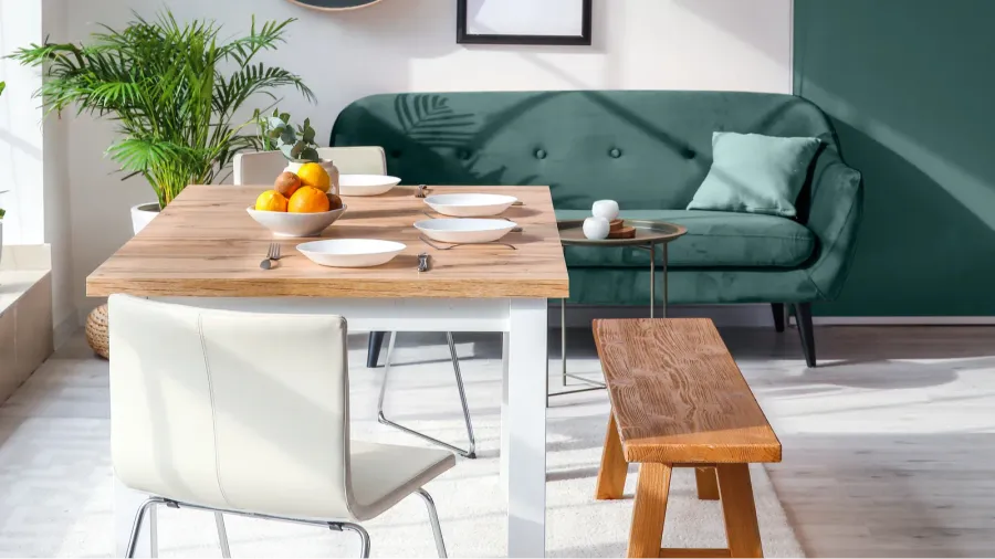 A stylish modern dining room interior with wooden tabletop, chrome chairs, and wooden bench.