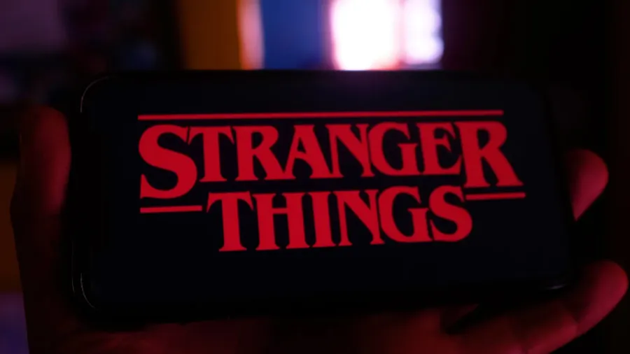 iphone with the netflix logo and computer with the stranger