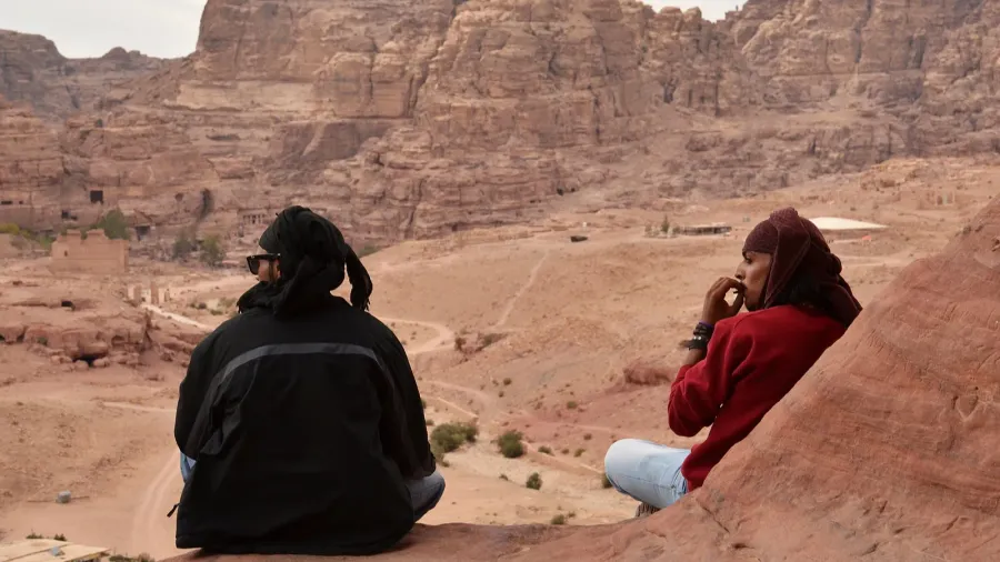 jordan petra two men bedouin sit on edge of a