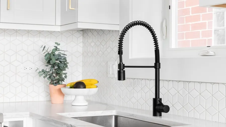 A matte black faucet over sink in a kitchen.