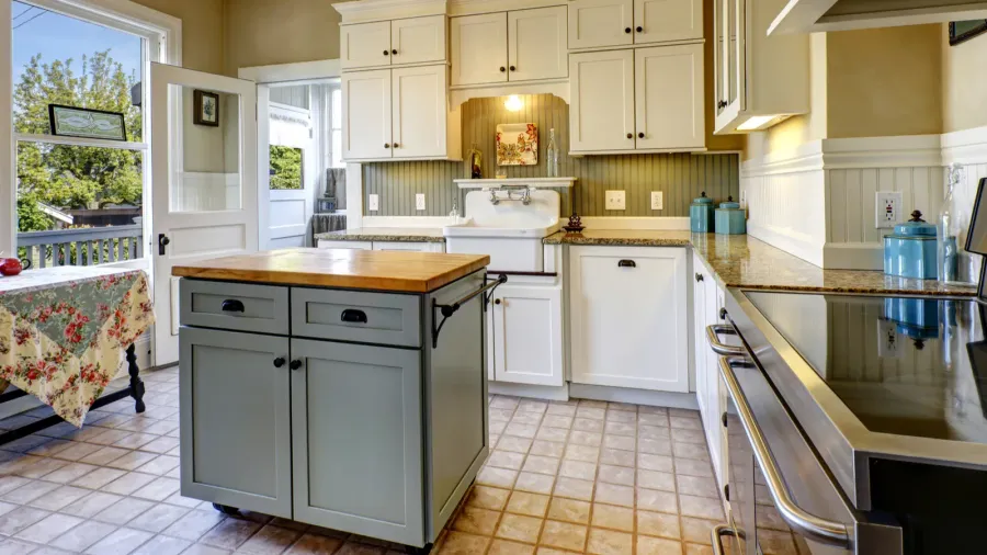 A bright kitchen with white cabinets and a central kitchen island.