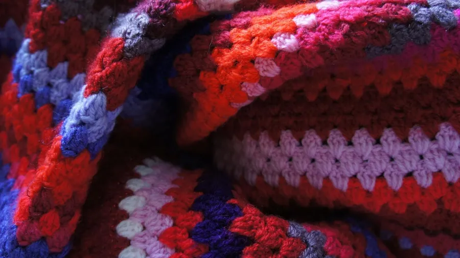 A colorful hand knitted throw blanket.
