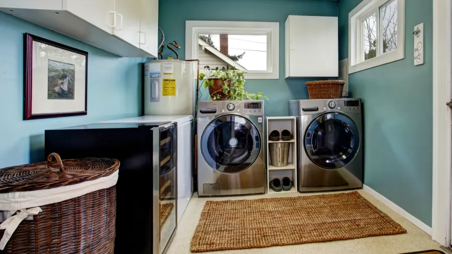 Laundry room with stacked washer and dryer, laundry baskets, and shelves.