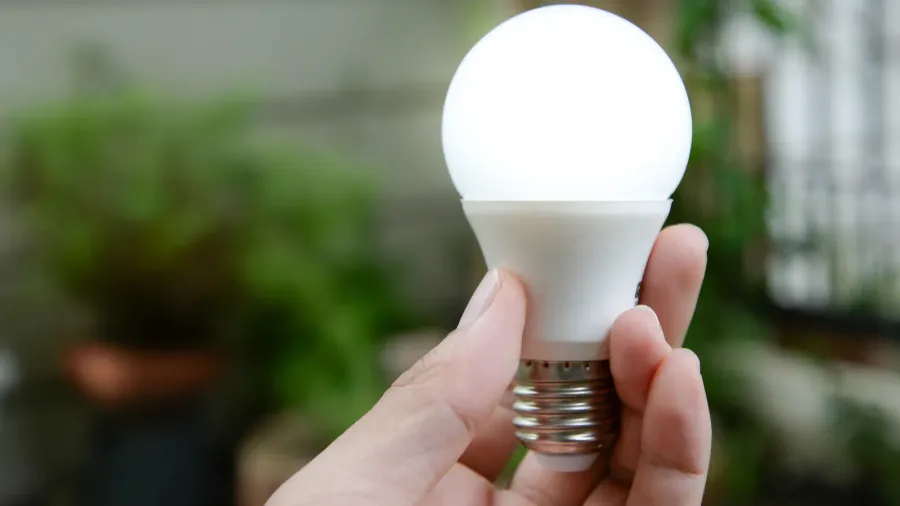 led bulb with lighting new technology of energy. A hand holding an LED light bulb.