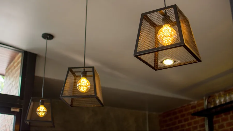 Metallic frame geometric ceiling pendant lights with Edison bulbs in them.