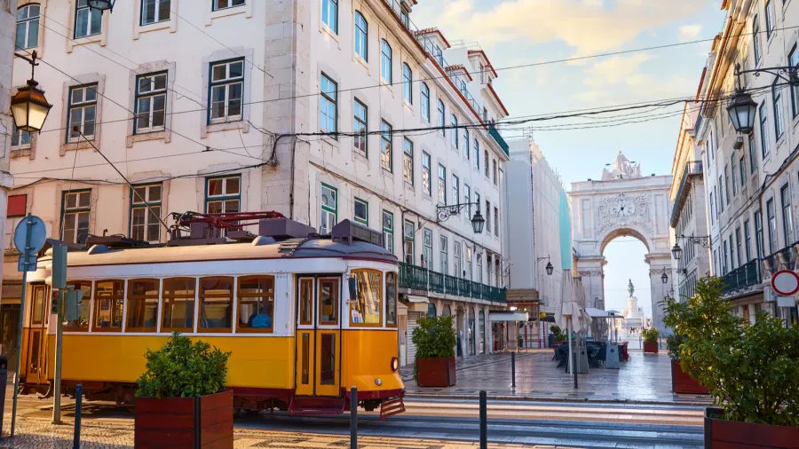 lisbon portugal yellow touristic retro tram triumphal arch of