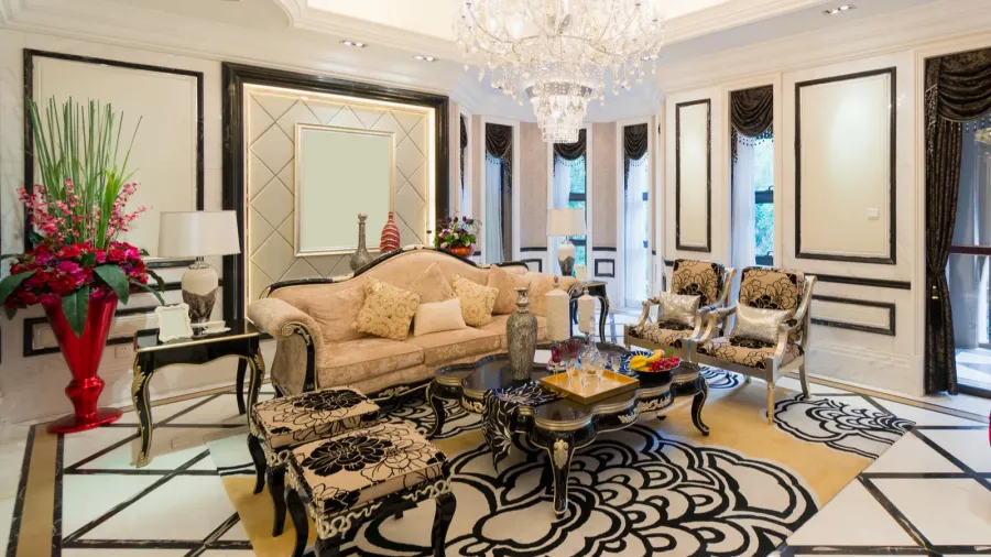 A luxury room interior with matching furniture set, beautiful patterned rug, and chandelier.