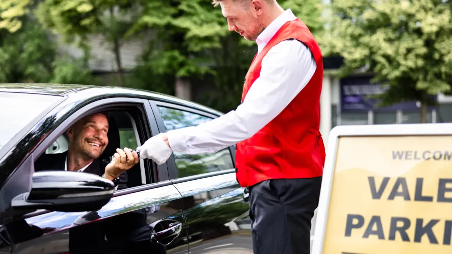 luxury valet service a man giving his car keys to