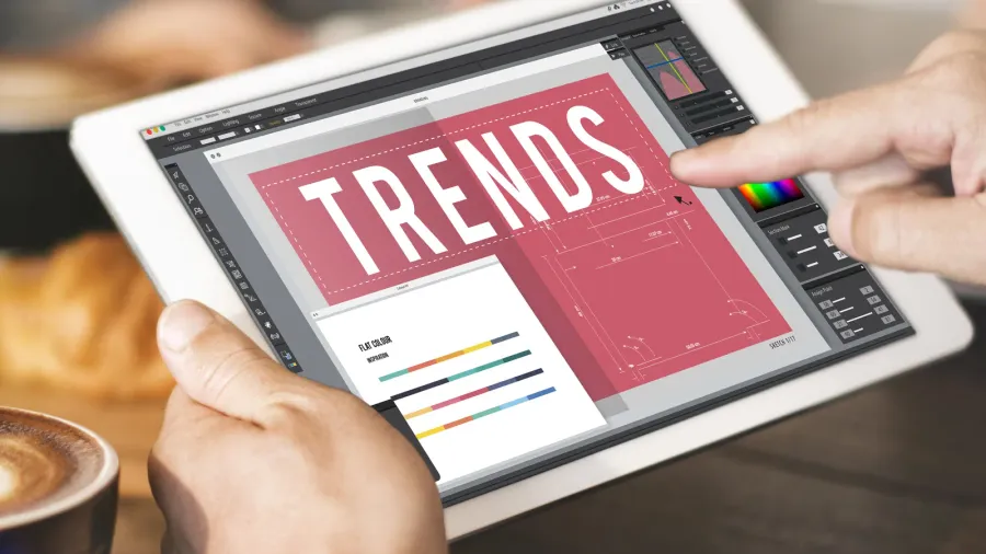 A man browsing digital tablet with "TRENDS" written on it.