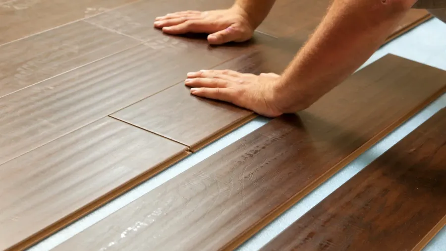 man installing new laminate wood flooring